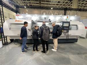 A group of people standing in front of a machine

Description automatically generated
